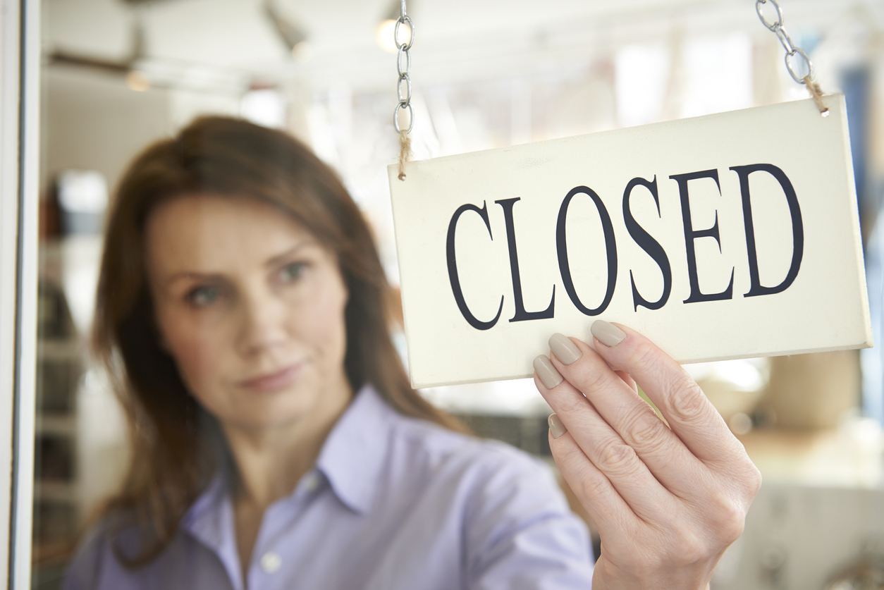Store Owner Turning Closed Sign In Shop Doorway Storm Damage Claim Denials | Insurance Attorney